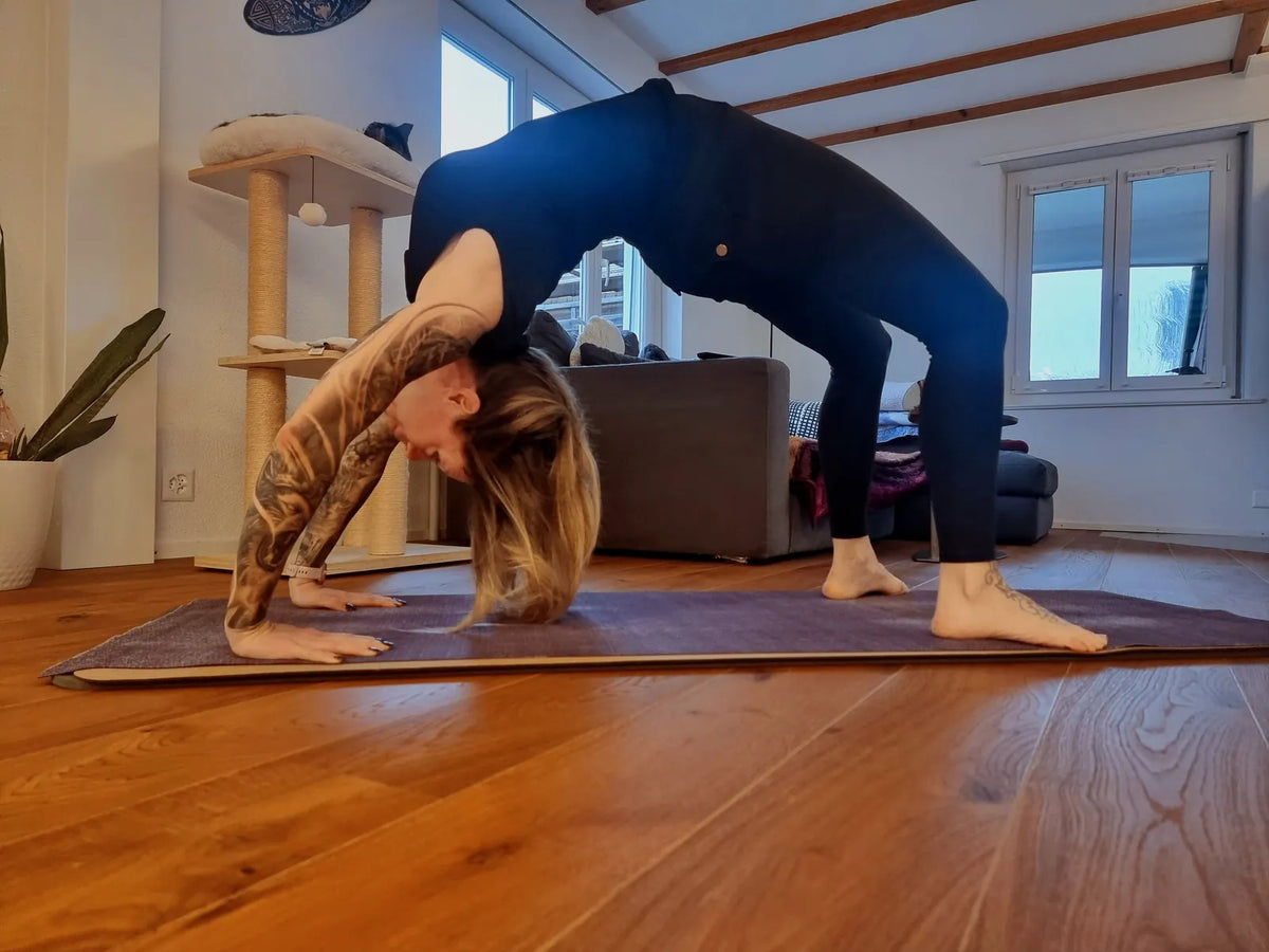 Kraftsportlerin Marion in der Rückbeuge (Brücke) auf der Yogamatte