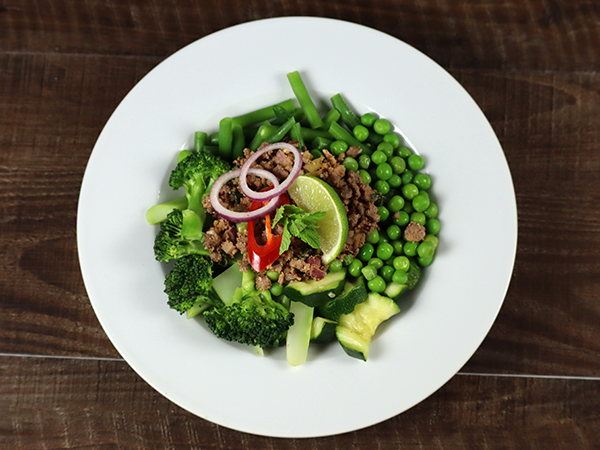 Rinds-Larb auf grünem Gemüsebeet 