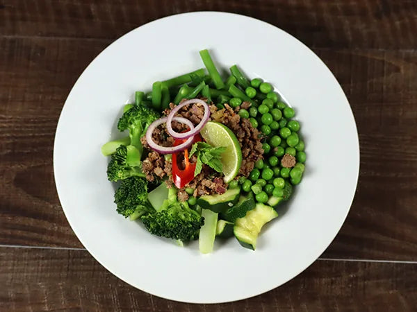 Rinds-Larb auf grünem Gemüsebeet 